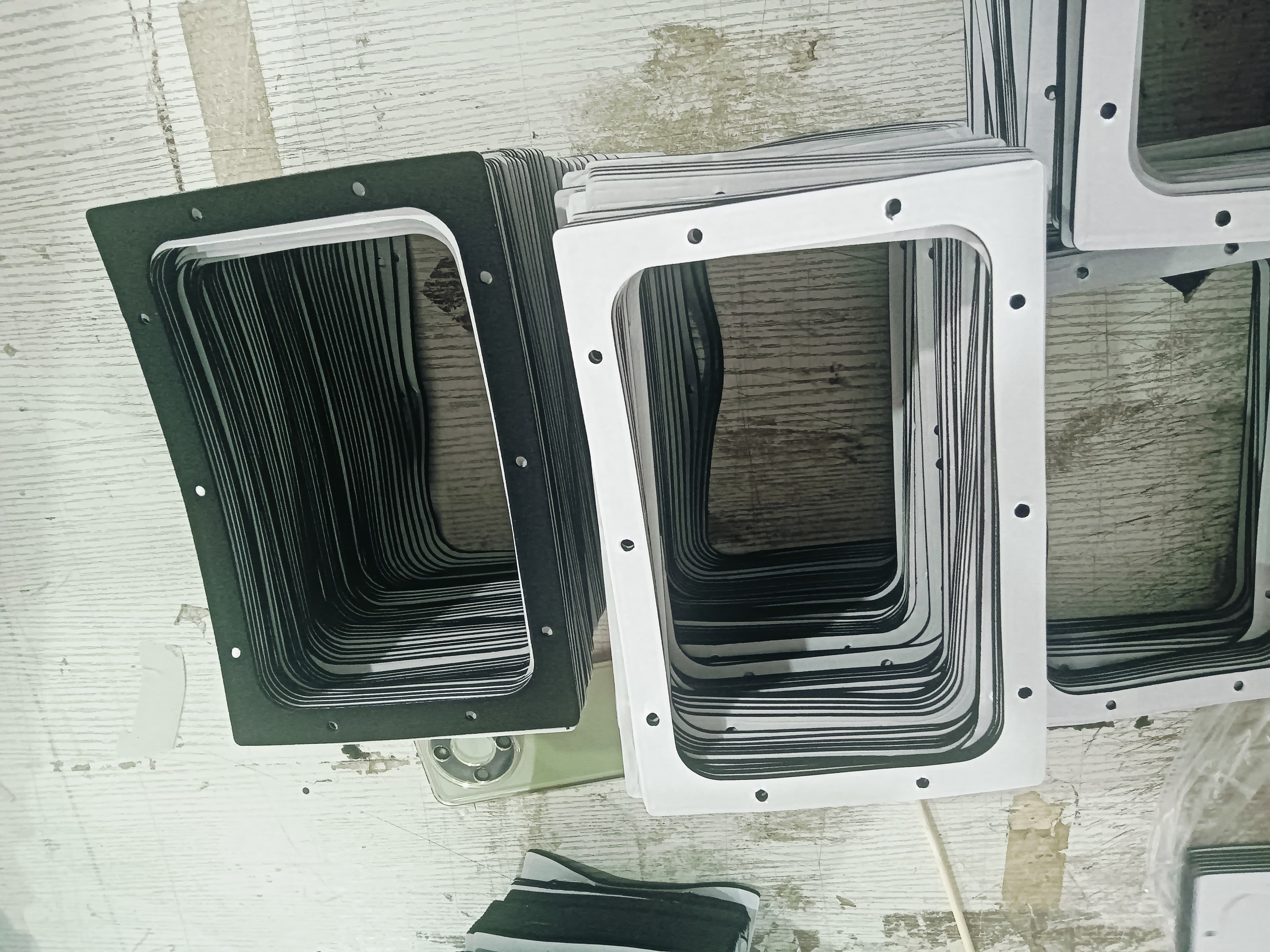 Stacked black and white die-cut foam gasket frames